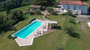 Ein Wohnhaus mit Pool, einer überdachten Terrasse und Blick auf die umliegende Landschaft.