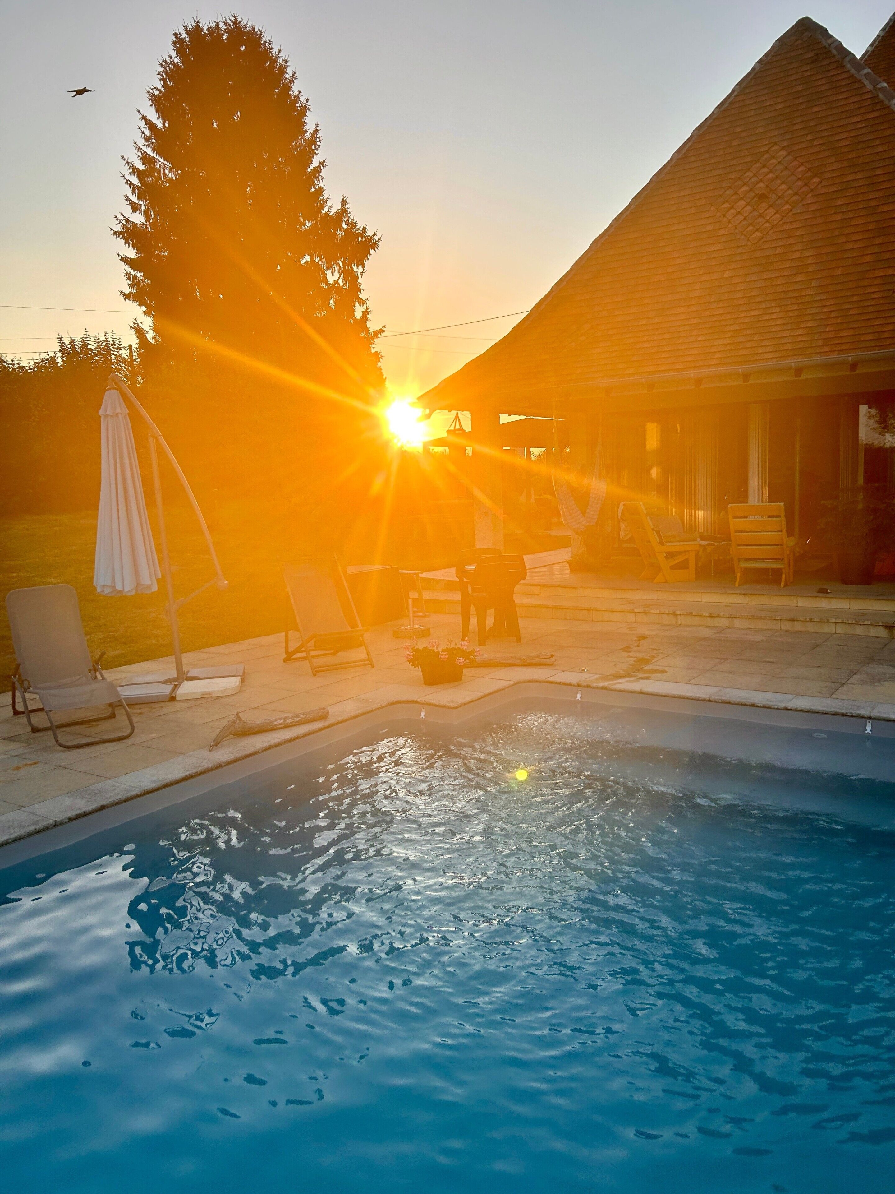 Une piscine avec des chaises longues et un bâtiment en arrière-plan.