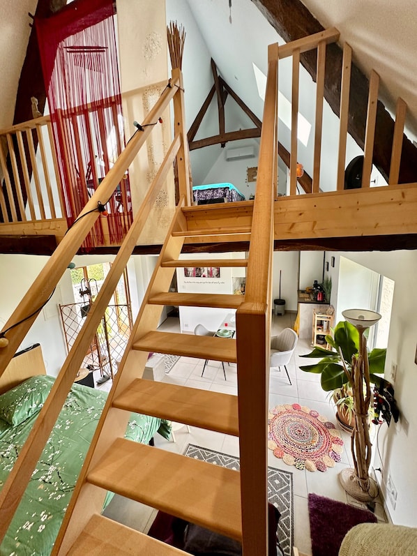 A wooden staircase leading to an upper level with a red curtain and a view of the interior.