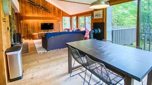 A cozy cabin interior with a dining area, a sofa, and a television. - Secluded Jackson Family Escape w/ Views & Deck (Jackson)