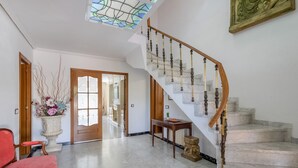 Una majestuosa escalera con escalones de mármol y balaustres de madera, que conduce a un piso superior.
