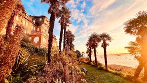 A coastal building with a balcony, palm trees, and a view of the sea. - Brittany Dream in Perros-Guirec – Sea View, Private Terrace, Ideal for Remote Work – High-Speed Wi-Fi (Perros-Guirec)