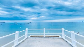 A concrete viewing platform with white railings overlooking a calm sea with boats. - Brittany Dream in Perros-Guirec – Sea View, Private Terrace, Ideal for Remote Work – High-Speed Wi-Fi (Perros-Guirec)
