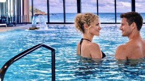 A couple in a swimming pool with a view of the ocean through large windows. - Brittany Dream in Perros-Guirec – Sea View, Private Terrace, Ideal for Remote Work – High-Speed Wi-Fi (Perros-Guirec)