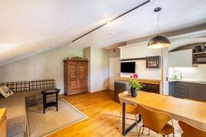 Un espacio tipo loft con comedor, kitchenette y sofá.