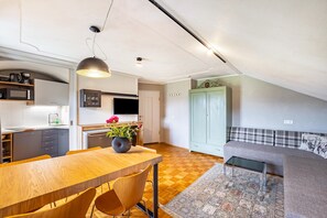 Une cuisine moderne avec une table à manger, des chaises, un téléviseur et un canapé dans l’espace salon.