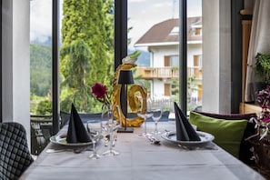 Une table à manger dressée avec des assiettes, des verres et un centre de table décoratif.