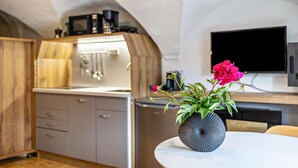 A modern kitchen with a microwave, coffee maker, and a flat-screen TV. - Residence Grünbacher Apartment 2 with Balcony and Shared Pool (Issengo)