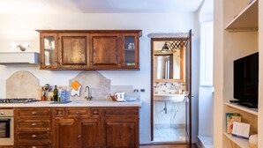 A kitchen with wooden cabinets, a stove, and a sink. - Apartment 'Appartamento Nel Cuore Di Volterra' (Volterra)