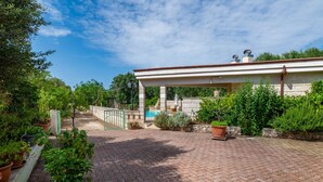 A covered outdoor area with a brick pathway leading to a building with a pool. - Villa 'Casa Rocco, Private Pool' with Private Pool, Wi-Fi and Air Conditioning (Ceglie Messapica)