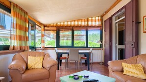 A living room with two leather sofas, a dining table with chairs, and a coffee table with remote controls. - Villa 'Casa Rocco, Private Pool' with Private Pool, Wi-Fi and Air Conditioning (Ceglie Messapica)
