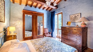 Une chambre à coucher avec un lit, une commode en bois et une chaise.