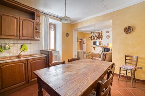A kitchen with wooden cabinets, a dining table, and chairs.