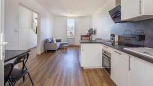 A modern kitchen with white cabinets, a built-in oven, and a countertop.