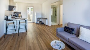 A modern living space with a kitchen, dining area, and a sofa.
