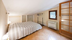 Une chambre à coucher avec un lit, un radiateur, une fenêtre et une porte.
