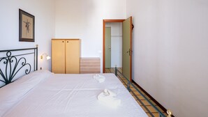 Ein Schlafzimmer mit einem Bett, einem Kleiderschrank, einem Spiegel und einer Treppe.