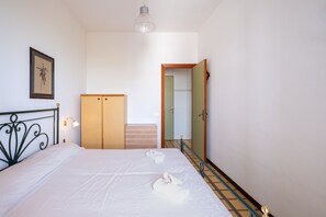 Um quarto com cama, guarda-roupa, espelho e escada.