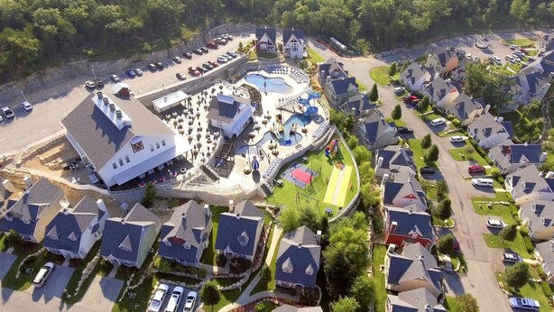 An aerial view of a resort with a large pool area, multiple buildings, and a parking lot. - Two Bedroom Cottage, Luxury Resort, Branson, Missouri  4044650 (Branson)