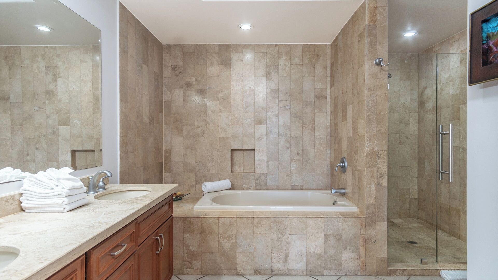 A modern bathroom with a freestanding bathtub, a glass-enclosed shower, and a marble vanity.