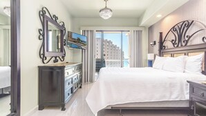 Een hotelkamer met een groot bed, een dressoir, een spiegel en een televisie.