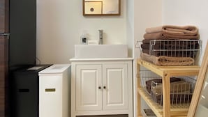 A bathroom with a white sink, mirror, and towel rack. - 1minute walk to stataion, direct bus to Haneda Airport! Easy access! (大田区)