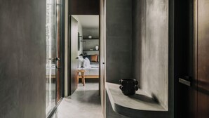 Ein modernes Interieur mit einer gewölbten Regaleinrichtung, einer Holzbank und einem Bett im Hintergrund.