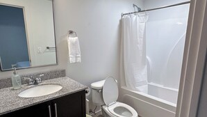 A bathroom with a sink, toilet, and shower.