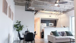 A modern living space with a dining area, kitchen, and seating area. - StayAE - High Rise (Baton Rouge)