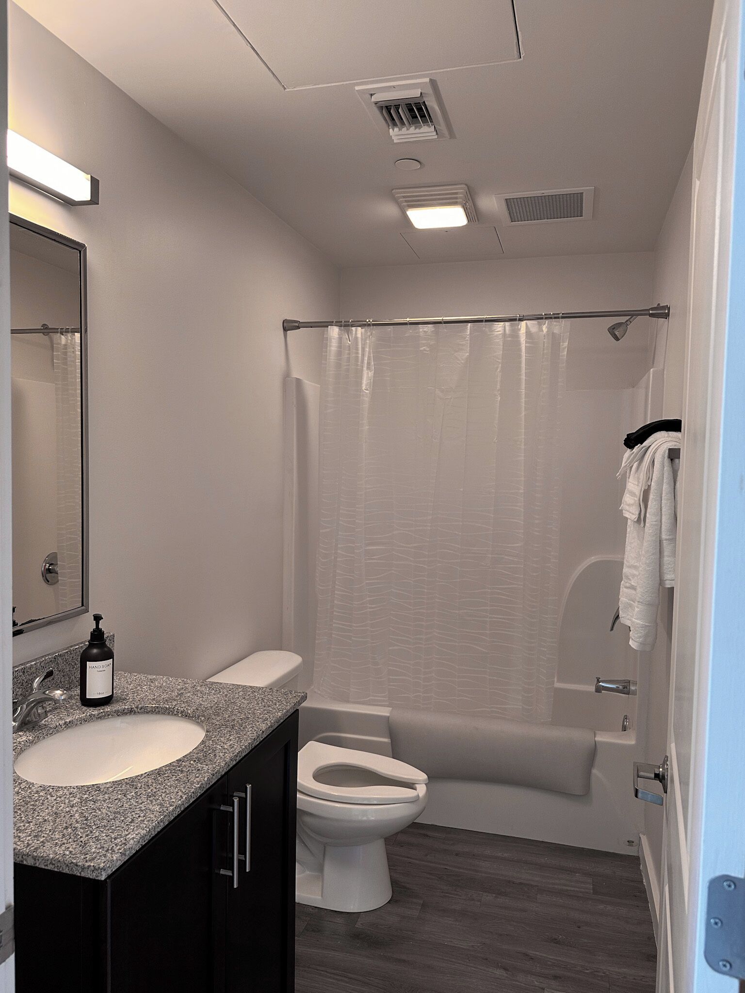 Ein modernes Badezimmer mit einem Doppelwaschtisch, Toilette, Badewanne und Duschvorhang.
