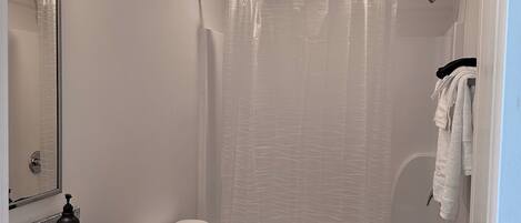 Ein modernes Badezimmer mit einem Doppelwaschtisch, Toilette, Badewanne und Duschvorhang.