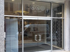 Une entrée d’immeuble avec une porte en verre sur laquelle figure le numéro 440 et le texte « ON THIRD ».