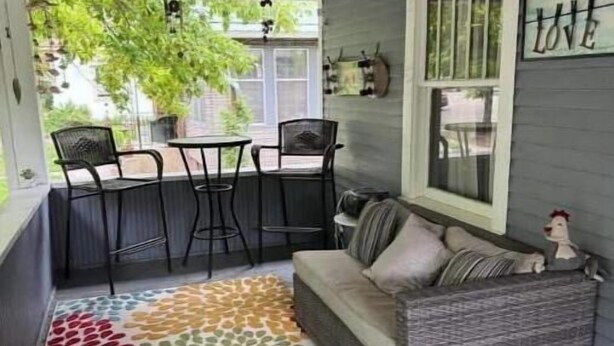 A cozy outdoor seating area with a gray sofa, a colorful patterned rug, and a wooden ceiling. - Remodeled Historical Home 2 blocks from CSU campus and 3 blocks to Old Town  (Fort Collins)