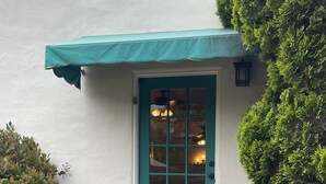 A teal door with a window, flanked by white walls and a small porch with steps. - Santa Barbara Mission Studio (Santa Barbara)