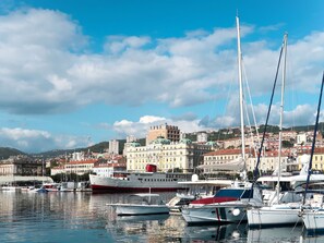 Boats docked in the harbor, surrounded by a vibrant urban area with diverse architecture.