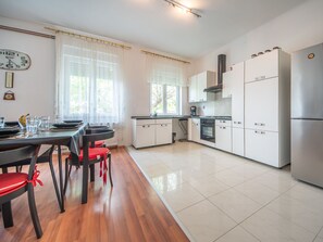 Enjoy meals in this kitchen with a dining table and chairs, oven, and stainless steel appliances.