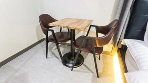 A small dining area with a wooden table and two brown chairs. - The Sharp Hotel (Changwon)