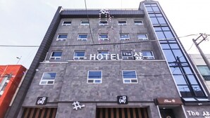 A hotel building with multiple windows, a sign reading "HOTEL The", and a parking sign below. - The Sharp Hotel (Changwon)