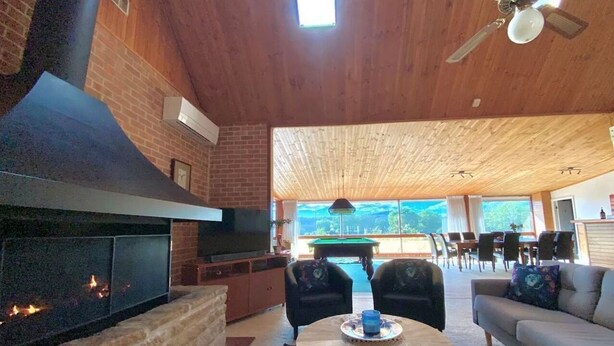 Amplia sala de estar con chimenea, mesa de billar y asientos cómodos.