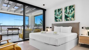 A modern hotel room with a large bed, a balcony with a view, and two abstract paintings on the wall. - Villa Yara | Pool - BBQ - Bar (Mijas)