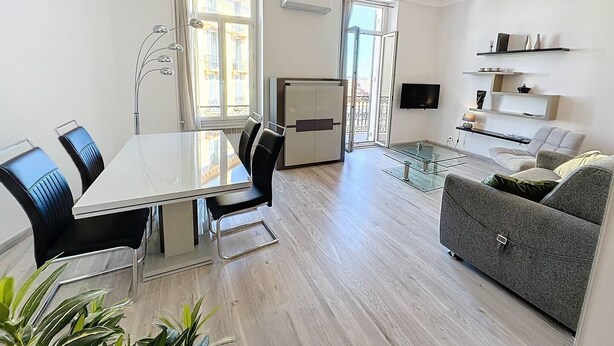 En moderne lejlighed med spiseområde, opholdsstue og balkon.
