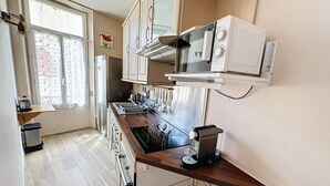 Et kompakt køkken med indbygget ovn, mikroovn og en lille vask.