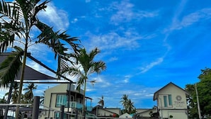 A beachfront property with a clear blue sky, palm trees, and a building labeled "TIJAMI". - Tijami Villa & Resort (Setiu)