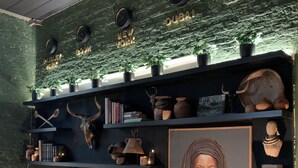 A wall with shelves displaying various artifacts, a television, and a framed picture.