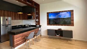 A modern kitchen with wooden cabinetry, a central island, and a ceiling fan. - Getaway Rooftop Apartment. Pet Friendly!! (Mérida)