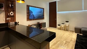 A modern kitchen with a large island, pendant lights, and a ceiling fan. - Getaway Rooftop Apartment. Pet Friendly!! (Mérida)