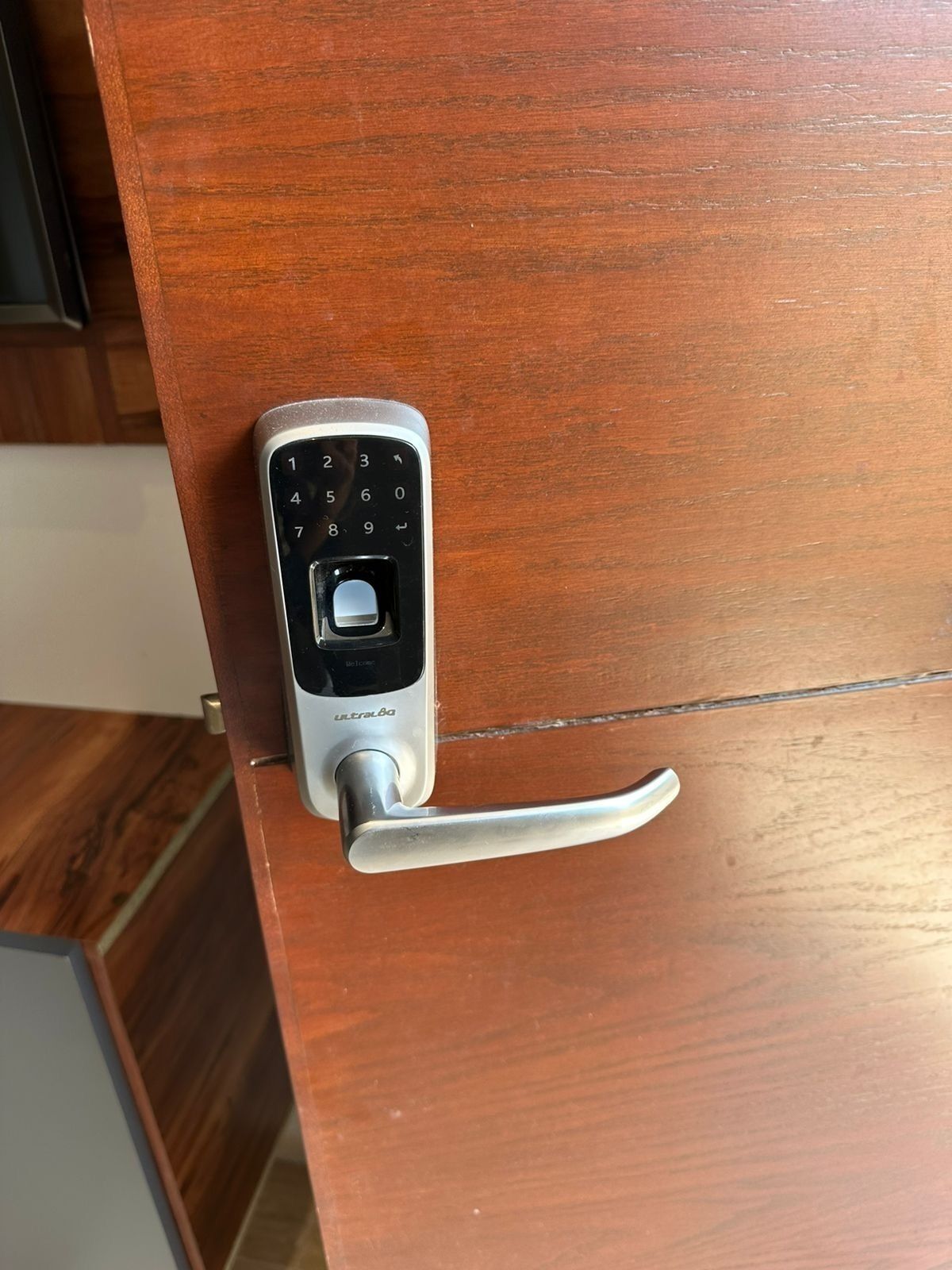 A door with a numeric keypad lock and a lever handle.