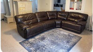 Ein modulares Sofa in einem Wohnzimmer mit einem gemusterten Teppich.