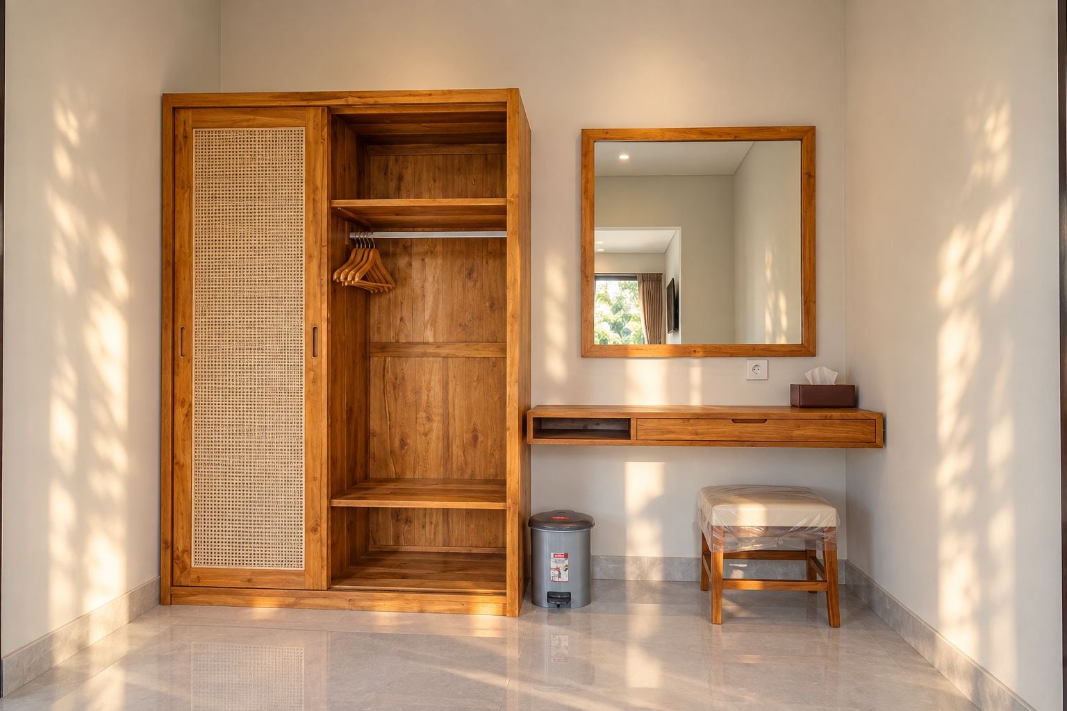 Ein Zimmer mit einem Holzschrank, einem Spiegel, einem kleinen Hocker und einem Mülleimer.