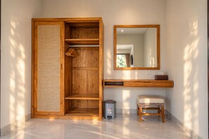 A room with a wooden wardrobe, a mirror, a small stool, and a trash bin. - Mahadewi Sunset Villa (Ubud)